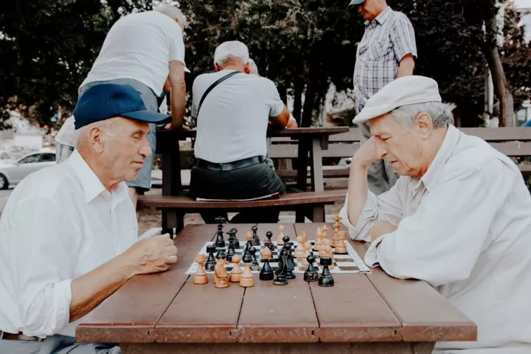 old men playing chess on a table